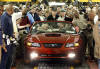 A red convertible 2004 Ford Mustang GT, the last vehicle built at the Dearborn Assembly Plant in Dearborn, Mich., rolls off the assembly line amid workers, Monday, May 10, 2004. Ford's oldest plant, the creation of founder Henry Ford that contributed to two U.S. war efforts and later was the birthplace of the iconic Mustang, opened in 1918. With the shuttering of the 86-year-old plant, Ford is moving production of the next-generation Mustang to a factory in Flat Rock, southwest of Detroit.