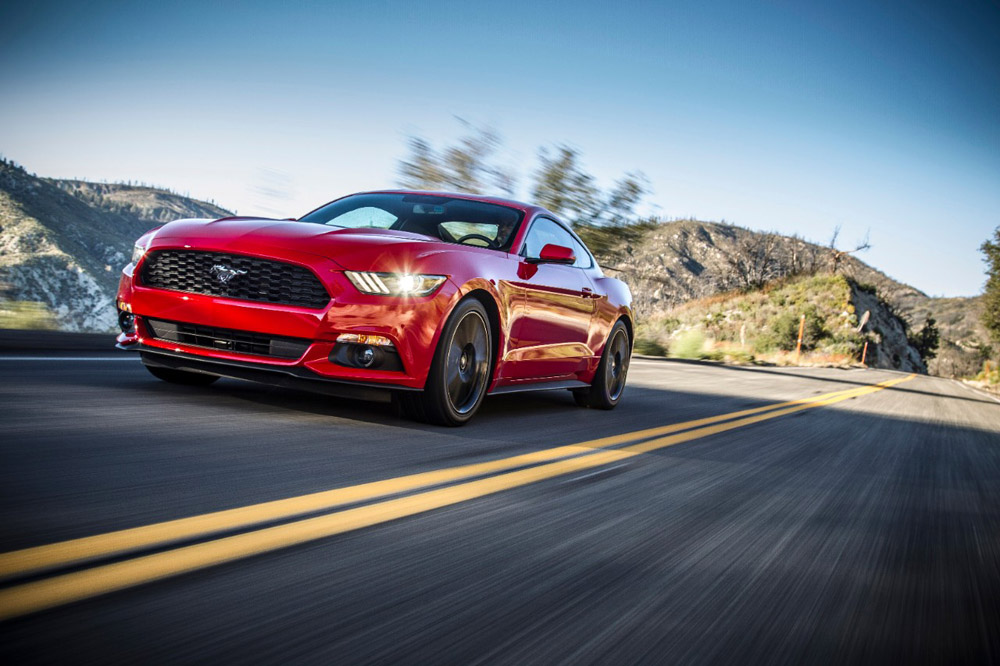 Red Orange 2015 Ford Mustang Driving Down Road
